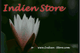 Weiße Blume vor dunklem Hintergrund mit rotem Text "Indien Store" oben.