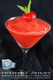 Rotes Slush-Getränk mit Erdbeere und Minze-Garnierung im Cocktailglas auf schwarzem Hintergrund.