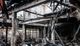 Charred remains of a burned building with exposed beams and debris scattered on the ground.