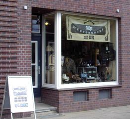 Ziegelgebäude mit Schaufenster eines Westernshops, Schild: "Billy's Westernshop seit 1992".