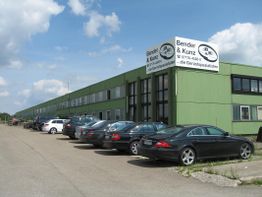 Grünes Industriebau mit Autos davor, Schild "Bender & Kunz, die Gerüstspezialisten" oben.