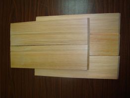 Holzplatten auf dunklem Holztisch gestapelt.