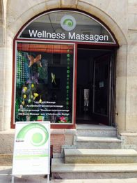 Schaufenster eines Wellness-Massagestudios mit Eingang und Werbetafel davor.