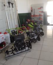 In esposizione, attrezzi agricoli e da giardino disposti ordinatamente su scaffali e pavimento.