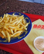 Pommes frites auf einem Teller mit Sauce und Serviette auf einem Tablett.