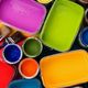 Barattoli di vernice colorata, inclusi rosso, viola, verde, blu, giallo e arancione.