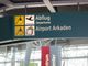 Schild im Flughafen mit Abflug- und Airport Arkaden-Hinweisen.