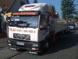 LKW mit Schriftzug "Schrott & Metall Recycling" und Telefonnummer, geparkt auf der Straße.