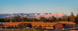 Motel with a mountain range in the background at sunset.