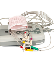 Dispositivo elettrocardiogramma con elettrodi colorati e carta a nastro con tracciato cardiaco.