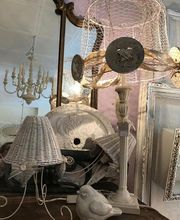 Vintage-Deko mit Lampen, einem Spiegel und einer Vogelstatue auf einem Tisch arrangiert.