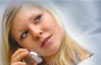 Junge Frau telefoniert mit einem Mobiltelefon und schaut nachdenklich zur Seite.