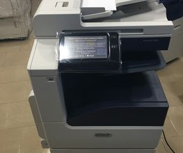 Fotocopiatrice moderna con display touchscreen, configurata su un pavimento piastrellato.