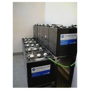 Baterías de almacenamiento conectadas en serie instaladas en una sala blanca sin decoración.