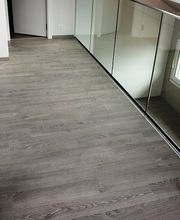 Flur mit Holzboden, weißer Wand und Spiegelwand, offenes Fenster sichtbar.