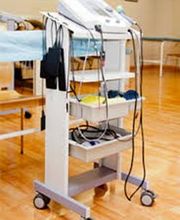 Carrito médico con equipo de hospital en una sala con suelo de madera clara.