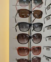 Gafas de sol variadas en exhibidor vertical en óptica.