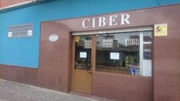 Fachada de un cibercafé con letrero "CIBER" sobre la puerta de entrada.