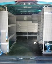 Transporter mit geöffneter Heckklappe zeigt geordnete Regale und Schubladen für Werkzeug.