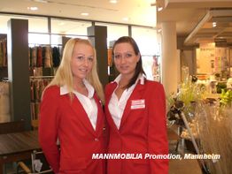 Zwei Frauen in roten Anzügen stehen nebeneinander in einem Geschäft.