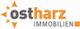 Logo von Ostharz Immobilien mit einem abstrahierten Sonnensymbol links vom Text.