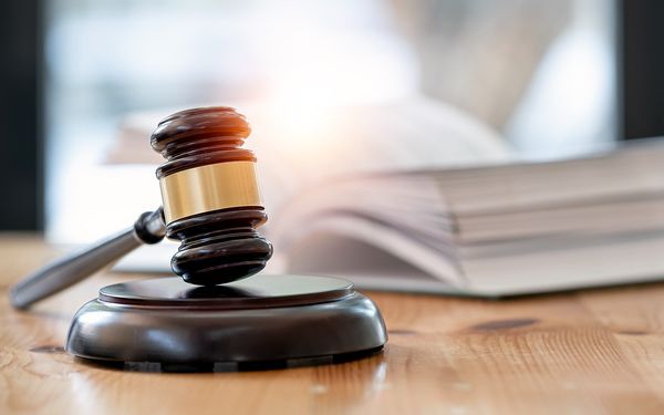 Hölzerner brauner Richterhammer auf dem Tisch, um die Nutzungsrechte und Lizenzvereinbarungen für Fotografen zu verdeutlichen.