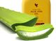 Aloe-Vera-Blatt mit Aloe-Vera-Gel in gelber Flasche im Hintergrund.