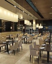 Restaurante moderno con mesas y sillas elegantes, iluminación suave y ambiente acogedor.