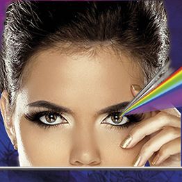 Eine Frau mit intensiven Augen, ein Prisma bricht Licht in Regenbogenfarben über ihr Gesicht.