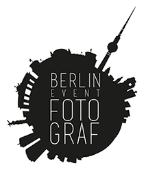 Schwarze Skyline mit Schriftzug "Berlin Event Fotograf" im Zentrum, Turmspitze zeigt nach oben.