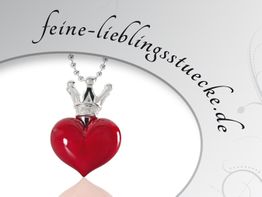 Rotes Herz-Amulett mit Krone vor feine-lieblingsstuecke.de-Schriftzug.