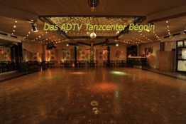 Leerer Tanzsaal mit Parkettboden und Beleuchtung, Text: "Das ADTV Tanzcenter Begoin".