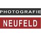 Schwarz-weiß-rotes Logo mit Text: "Photografie Neufeld".
