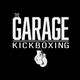 "The Garage Kickboxing logo with hanging boxing gloves below the text on a black background."