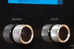 Zwei silberne Reglerknöpfe mit den Aufschriften „Balance“ und „Volume“ an einem schwarzen Gerät.