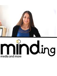 Eine Frau steht vor einem Plakat mit der Aufschrift "minding media and more".