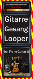 Gitarrenunterricht Brühl mit Gitarre, Gesang, Looper. Mann sitzt mit Gitarren und Accessoires.