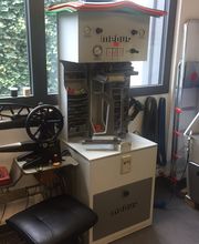 Werkstatt mit Maschinen zur Schuhreparatur und Fenstern im Hintergrund.