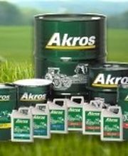 Contenitori di olio Akros in vari formati su sfondo erboso.