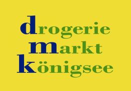 Gelber Hintergrund mit den Wörtern: drogerie markt königsee in blau und grün geschrieben.