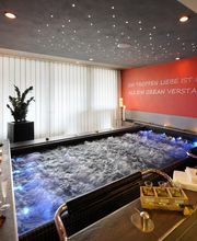 Whirlpool in einem modernen Raum mit roter Wand und Pflanzen. Entspannende Atmosphäre.