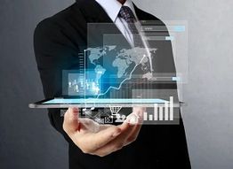 Man in suit holding a tablet with holographic charts and world map projections.