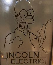 Dibujo de personaje animado con cable, texto "Lincoln Electric" abajo.