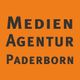 Orange Hintergrund mit schwarzem Text: "Medien Agentur Paderborn".