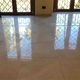Pavimento lucido in marmo riflette la luce delle finestre con grate.