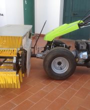 Macchina agricola gialla e verde su pavimento in cotto, con attrezzo per raccolta meccanizzata.