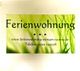 Werbung für eine Ferienwohnung mit Website und Telefonnummer auf grünem Hintergrund.
