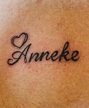 Tattoo met de naam "Anneke" en een getekend hart erboven.