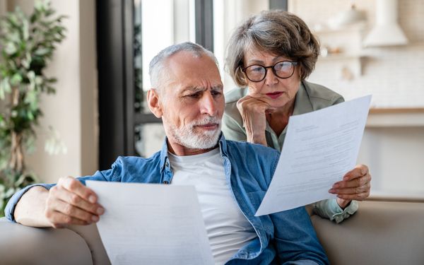 Ein älteres Ehepaar liest sich die Dokumente zu ihrer Rente durch.