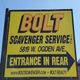 Yellow sign for Bolt Scavenger Service, entrance in rear, 5819 W. Ogden Ave. Arrow points right.